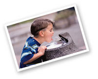 boy drinking out of a water fountain